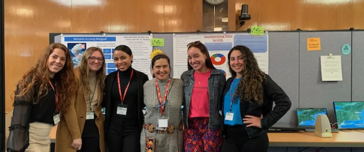 6 women standing in front of two student project presentations.