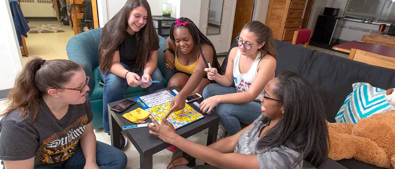 Students playing a board game in a residence hall.
