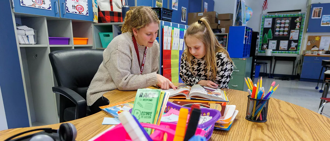 Elementary Education student teaching a child how to read.