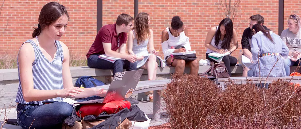 Students sit outside in the quad during spring semester