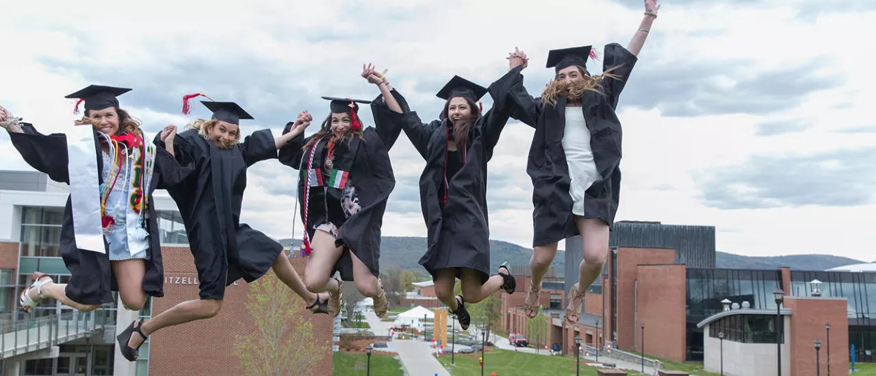Graduates jump in caps and gowns