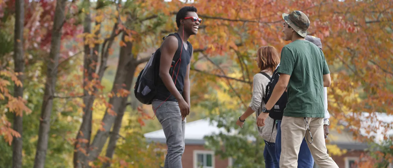 Students talking while walking around campus on a Fall day.