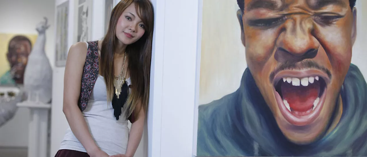 Ayana Namada, an international student from Japan, graduated from SUNY Oneonta on May 16, 2015, with a bachelor’s degree in Art. She stands beside her oil painting titled Siwon, one of three of her works selected for the Annual Juried Student Art Exhibition in the Martin-Mullen gallery.