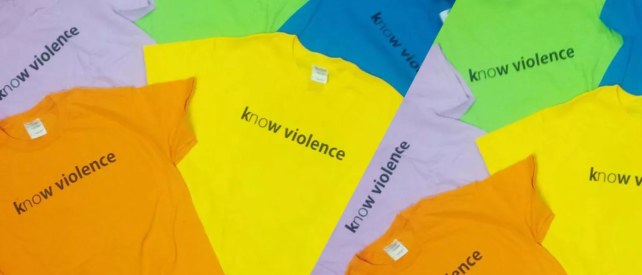 Pile of shirts that say know violence on them