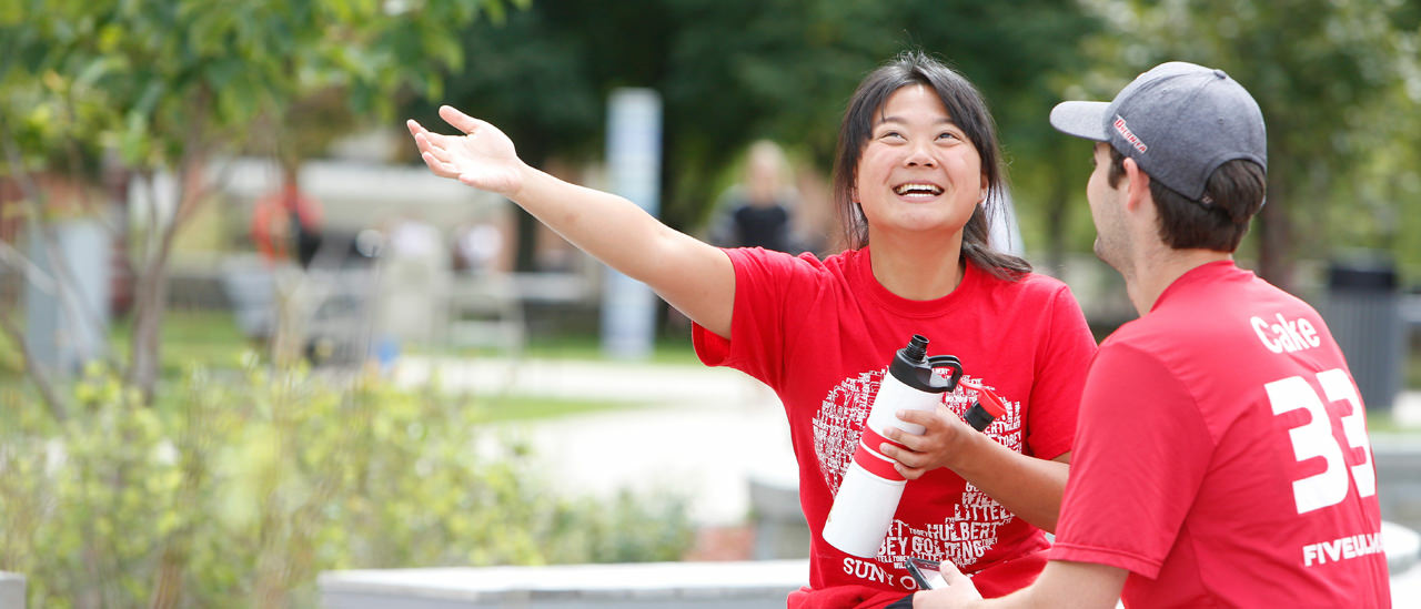 Students having a conversation wearing red day shirts in the quad