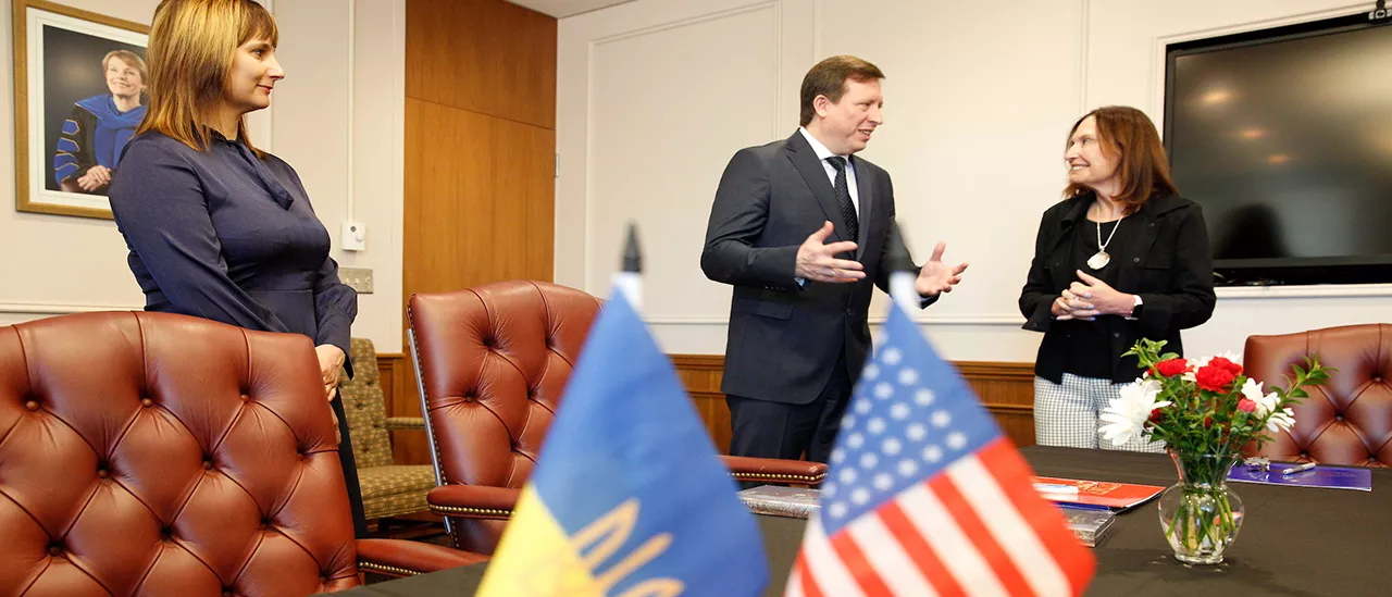 President Morris talks to a representative from Ukraine, with the American and Ukrainian flags in the foreground