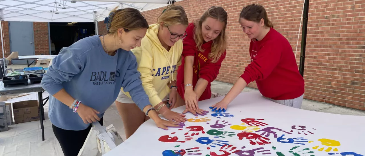 Students Place Painted Hand Prints on the WIngs