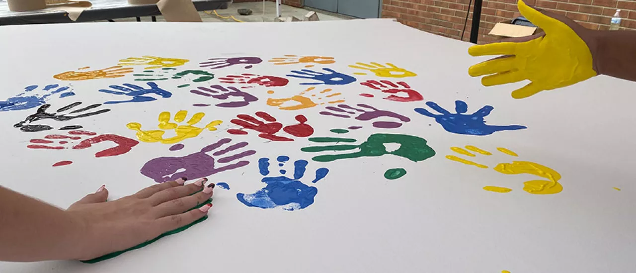 Students Place Painted Hand Prints on the WIngs