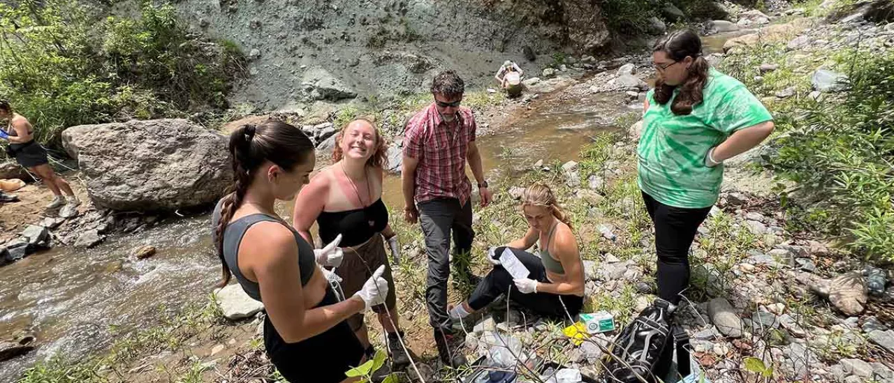 Guatemala feculty-led trip students doing research by stream