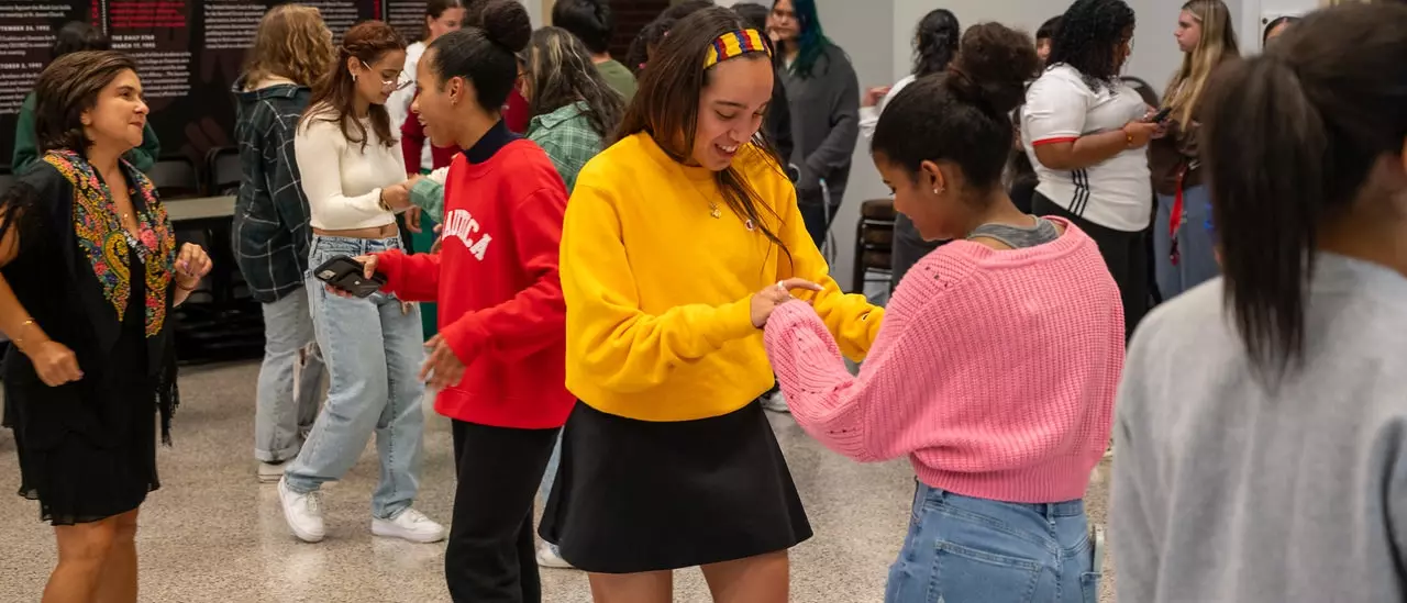 Faculty and students dancing together at a CRJIE event.