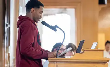 An English major reads prepared material at the Common Read Conference.