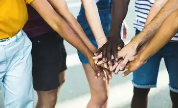 A variety of hands overlap each other in a show of solidarity