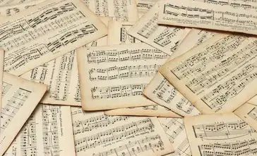 Multiple sheets of music scattered in a pile