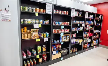 Shelves filled with food along a wall in the Red Dragon Food Pantry