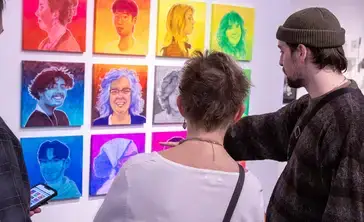 Patrons contemplate colorful pieces in the art gallery