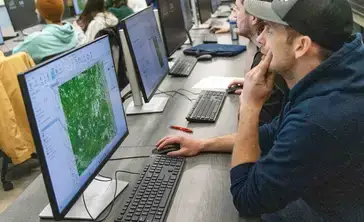 Student in blue hoodie in Geographic Information Systems (GIS) Class