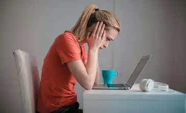 Stressed student looking at laptop screen.
