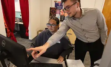 Student workers help each other in the Student Employment Services office.