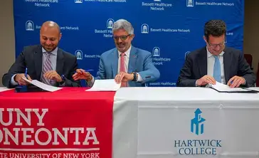 Executives smile during a signing ceremony.