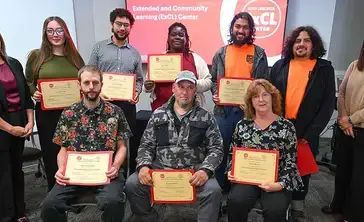 Graduates of the manufacturing bootcamp pose with their certificates.