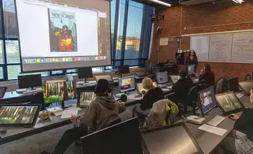 Students sit at digital workstations during a graphic design class.
