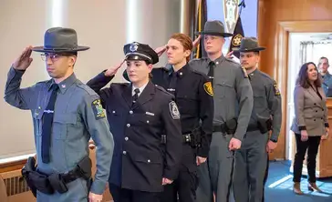Otsego County Law Enforcement cadet graduates saluting.