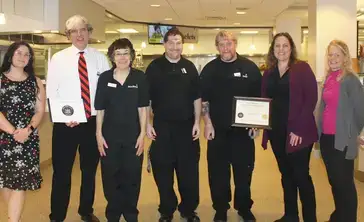 Members of the SODEXO team pose with an award.