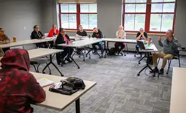 Students participate in a group discussion in a classroom.