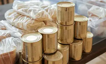 Stack of donated canned goods on a table.