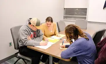 Students help each other with tax paperwork.