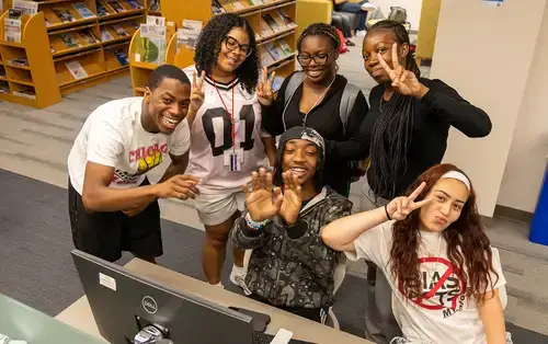 Summer Academy Students pose for photo in the library