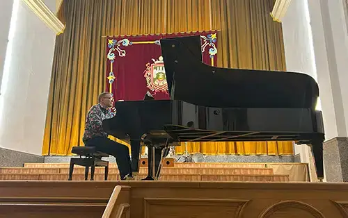 Professor Adam Kent playing piano on stage