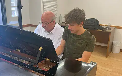 Magnus playing piano with another person