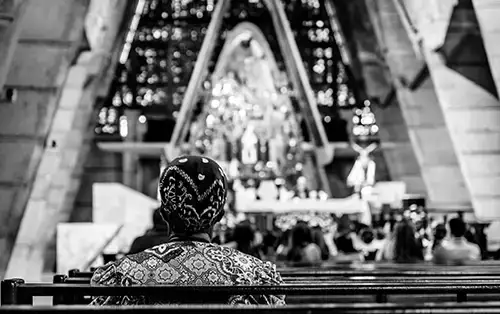 black and white photo of a woman sitting in a church