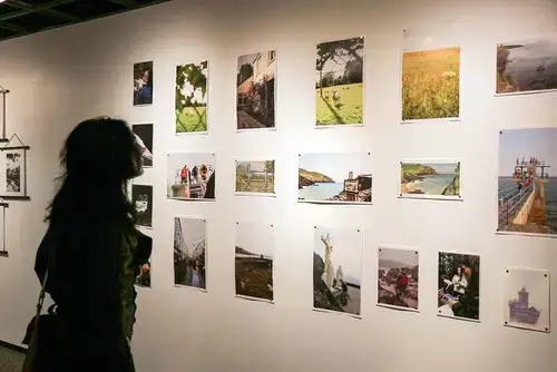 Gallery patron reviews a submission for the Jean Parish Scholarship in a SUNY Oneonta gallery.