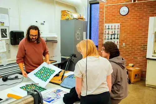 Artist-in-residence Natan Diacon-Furtado works with students in one of the art studios.
