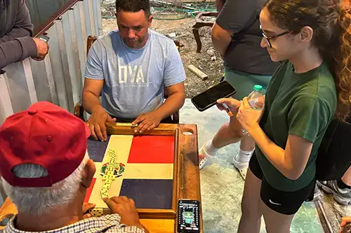 Students interview locals playing board game