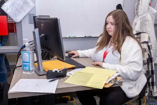 Student works with a computer to help with tax return assistance.