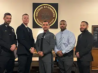 Four new DCJS certified instructors pose for a graduation photo.