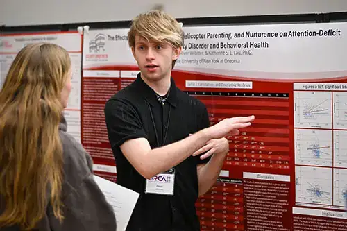 Student explains their research to another student