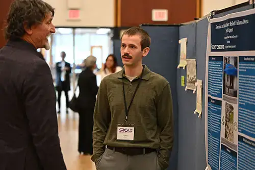 Student explains their research to a faculty member