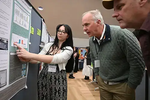 Student explains their research to faculty member