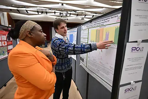 Student explains their research to faculty member