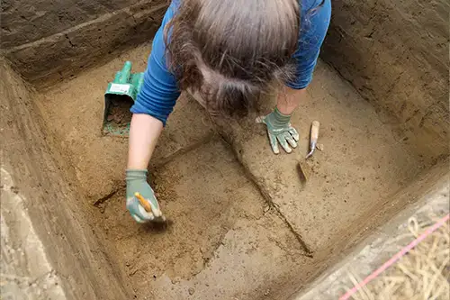 Archaeology student digs for artifacts