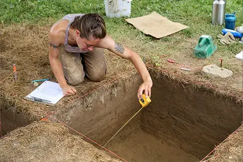 Archaeology student measures site depth