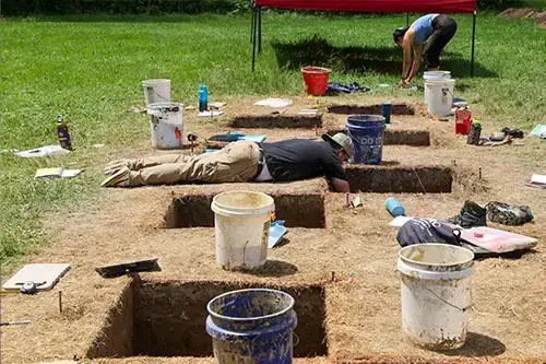 Archaeology student digs for artifacts