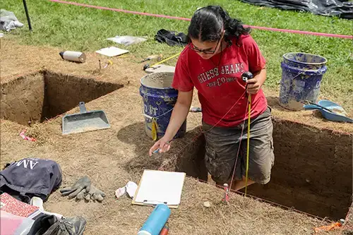 Archaeology student digs for artifacts