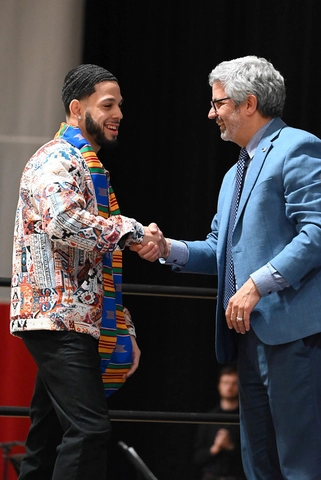 President Cardelle shaking hands with a Kente graduate.