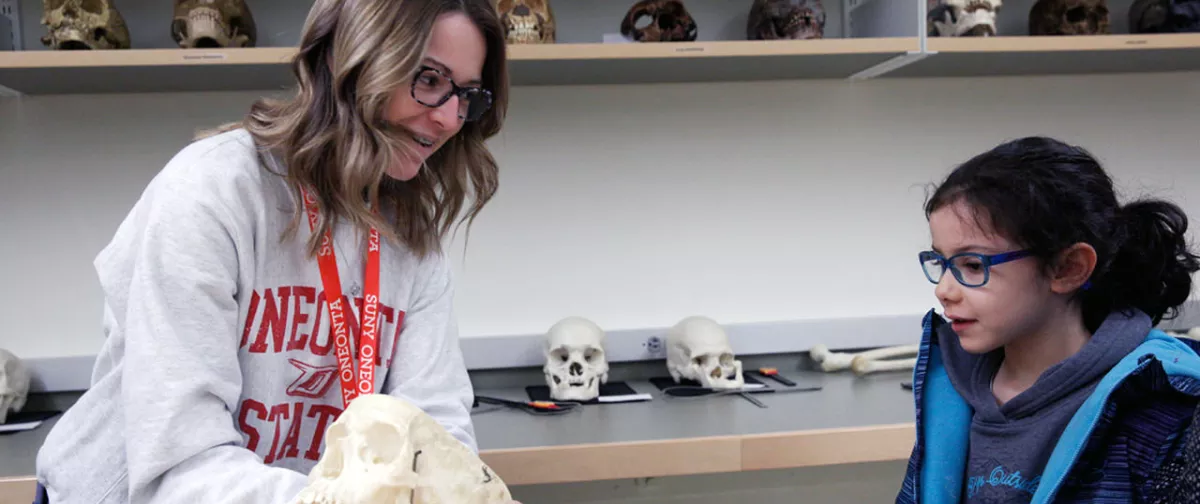 Student presenting a skull to a little girl.