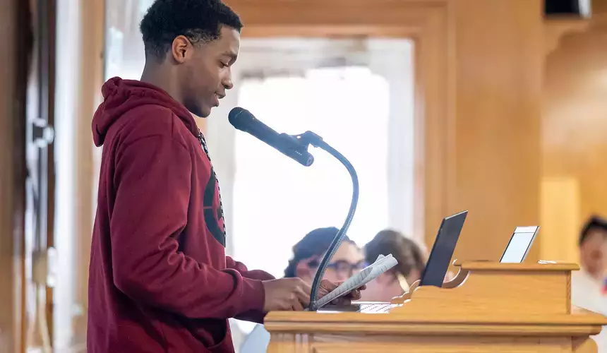 An English major reads prepared material at the Common Read Conference.